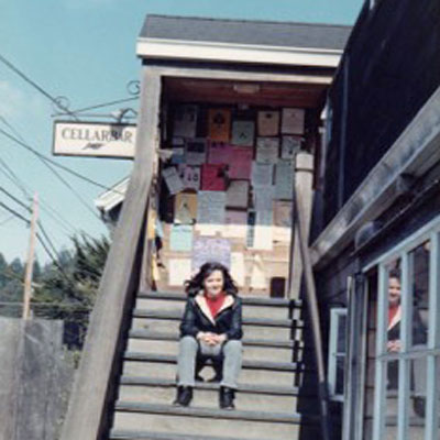 Waitress Carolyn Lundquist sitting on outside stairs to new Cellar Bar